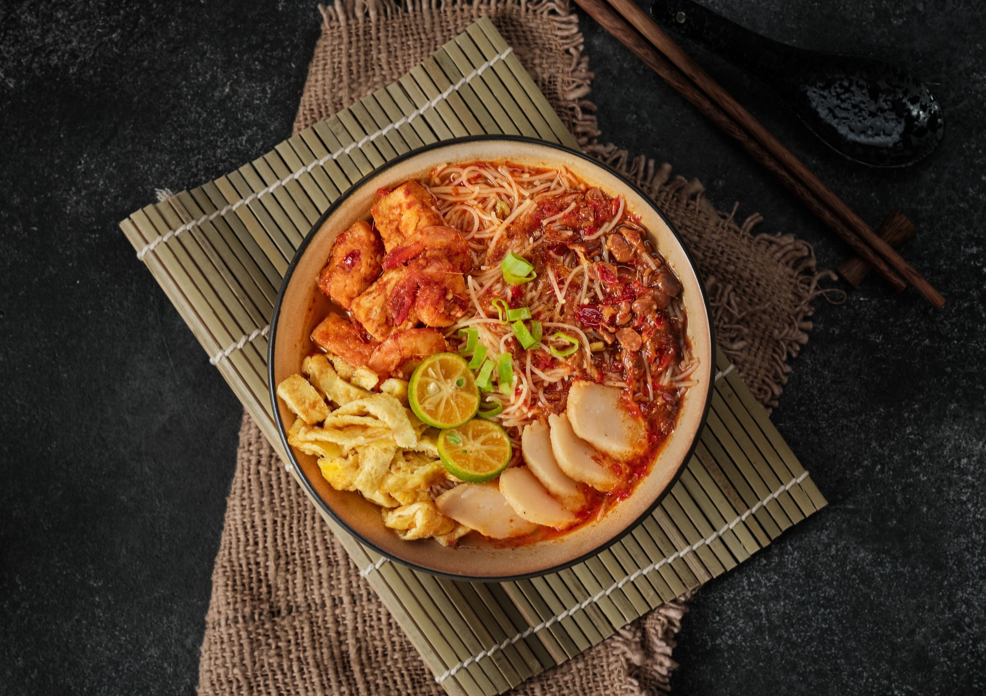 LIVE STN- Nyonya Mee Siam with Condiments Rice Vermicelli served in Assam Gravy with Diced Dried Tau Pok, Eggs, Lime, Chinese Chives & Sambal